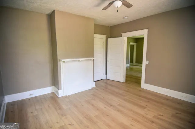 a view of an empty room with wooden floor