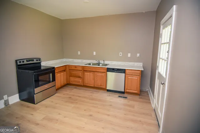 a view of a kitchen with a sink and stainless steel appliances