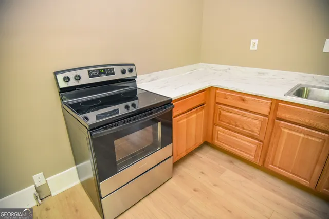 a kitchen with granite countertop a stove a sink and dishwasher
