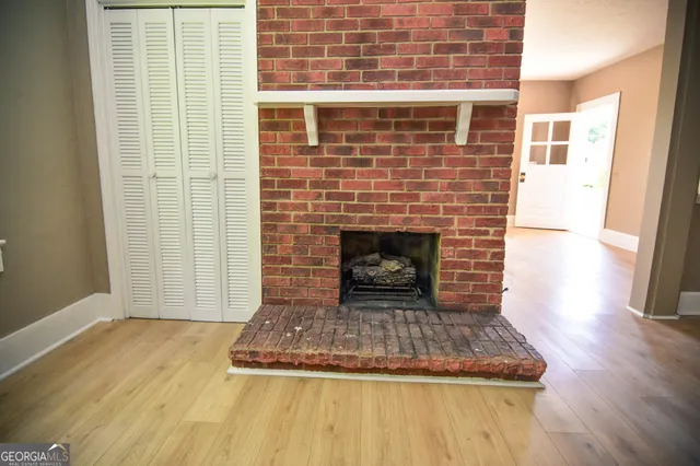 a view of empty room with wooden floor and fireplace