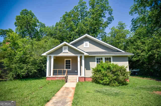a front view of a house with a yard and green space
