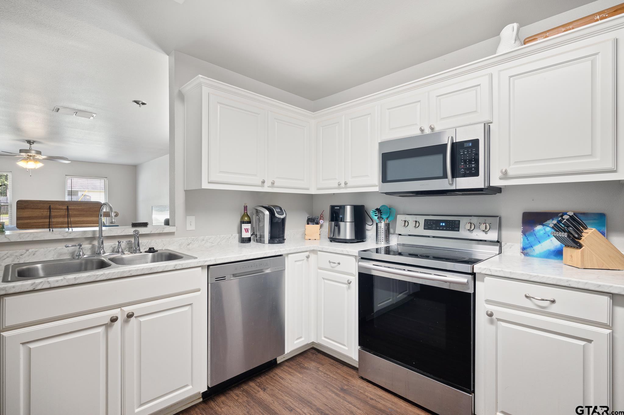 421 Alexander Street Kilgore, TX 75662 - Photo 11 of 24 a kitchen with cabinets stainless steel appliances a sink and wooden floor