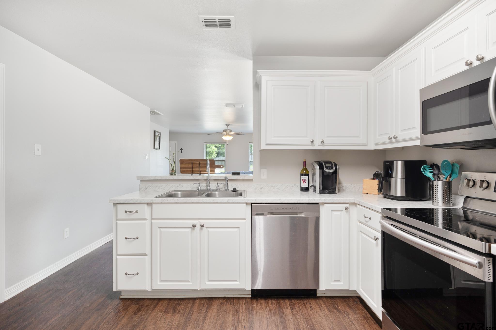 421 Alexander Street Kilgore, TX 75662 - Photo 12 of 24 a kitchen with stainless steel appliances granite countertop a sink and cabinets with wooden floor