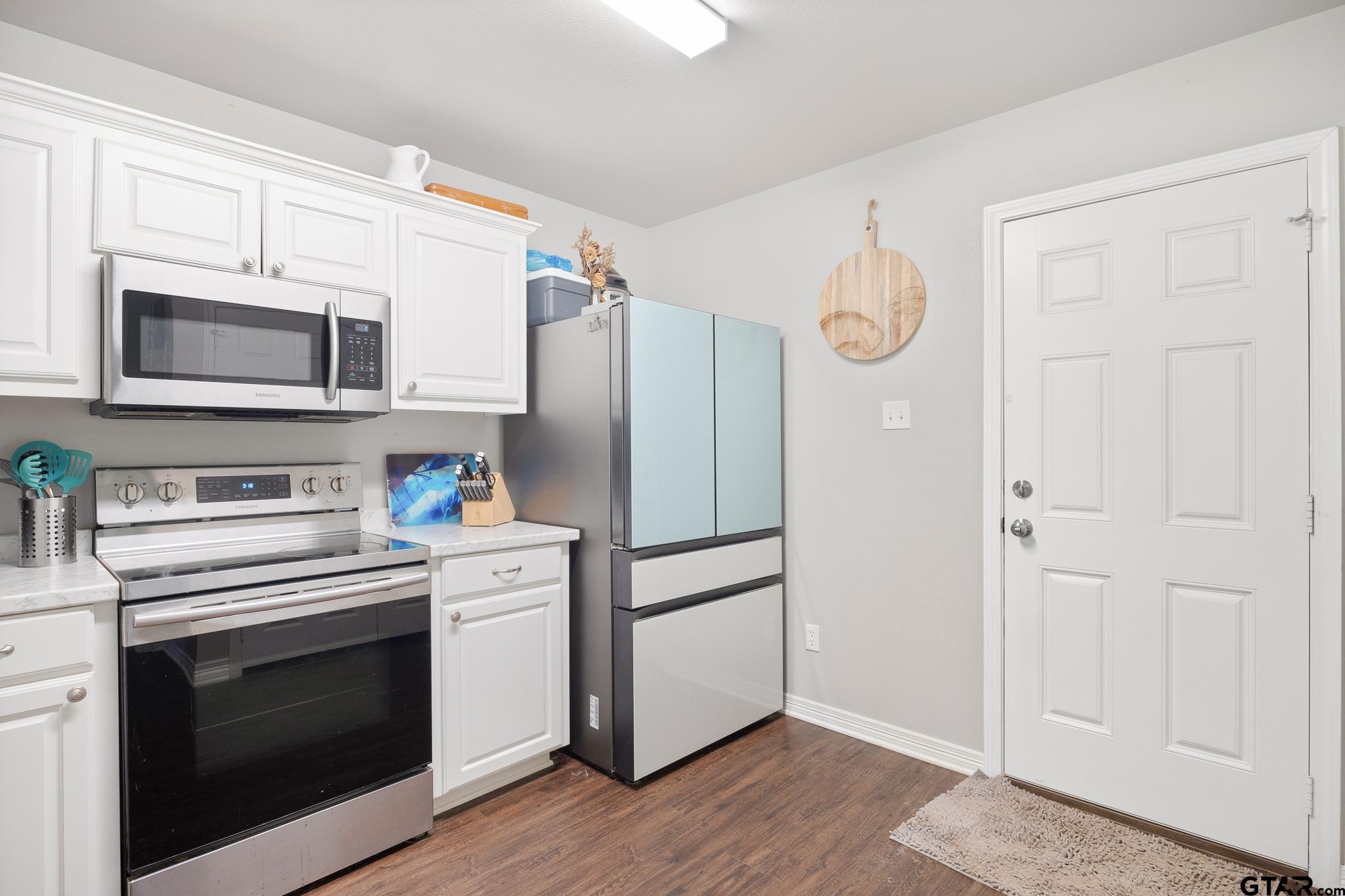 421 Alexander Street Kilgore, TX 75662 - Photo 13 of 24 a kitchen with stainless steel appliances white cabinets white stainless steel appliances and a refrigerator