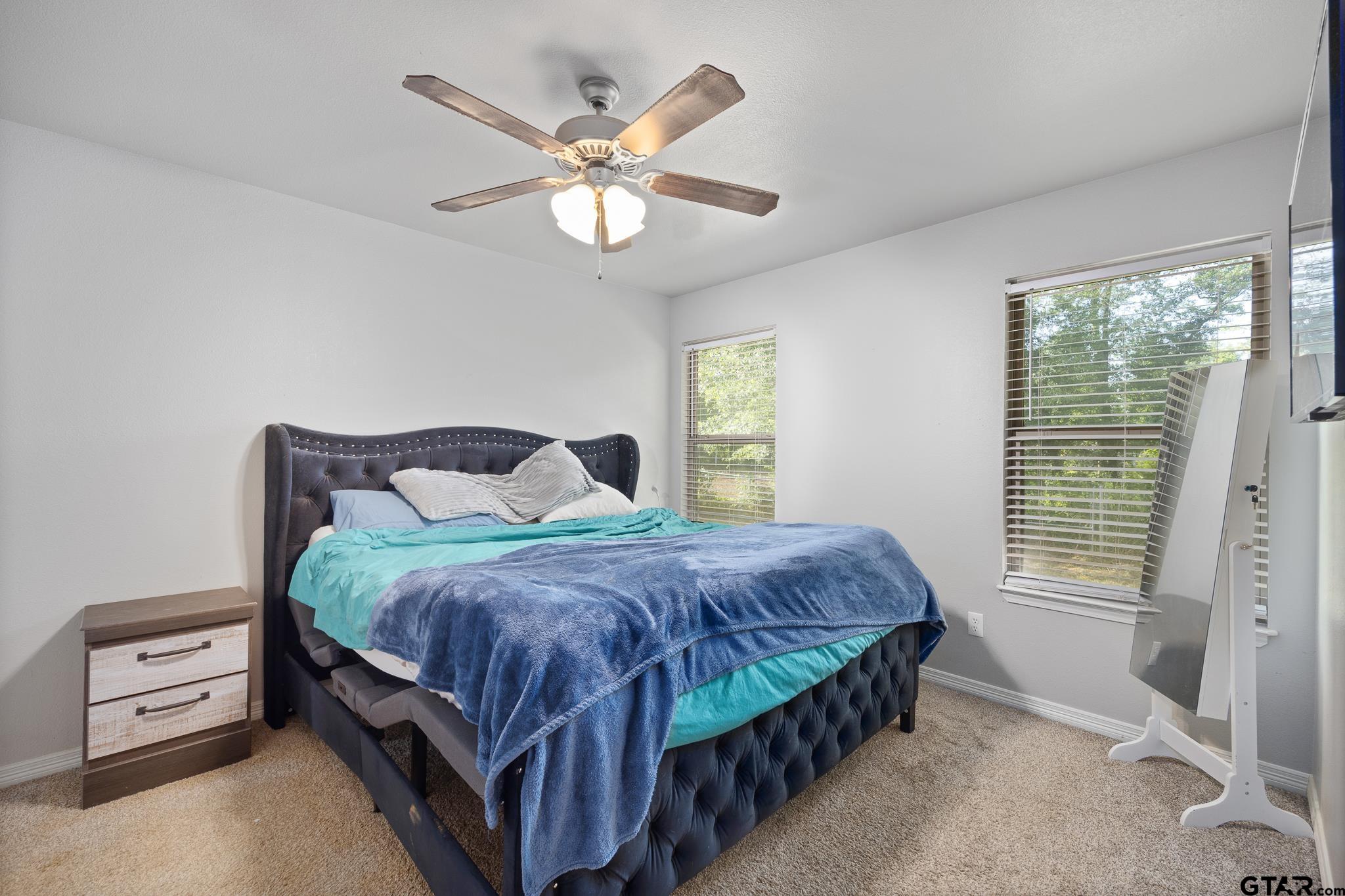 421 Alexander Street Kilgore, TX 75662 - Photo 19 of 24 a bedroom with a bed and a chandelier
