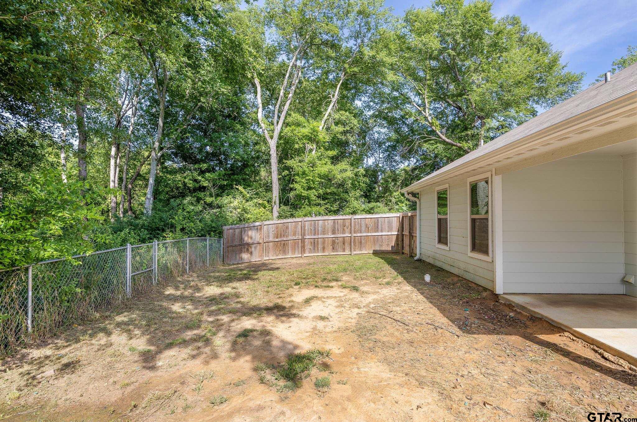 421 Alexander Street Kilgore, TX 75662 - Photo 22 of 24 a view of backyard with large trees and wooden fence