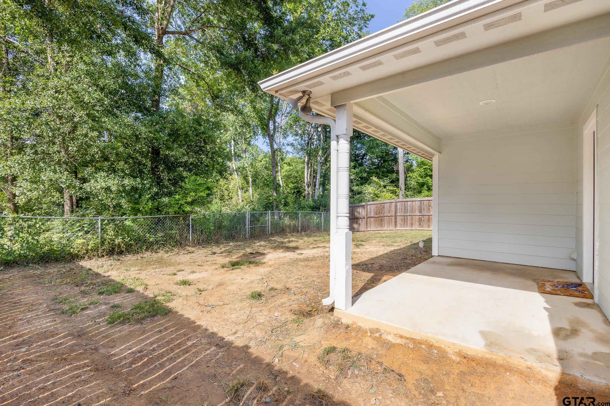 421 Alexander Street Kilgore, TX 75662 - Photo 23 of 24 a backyard of a house with wooden floor and floor to ceiling window