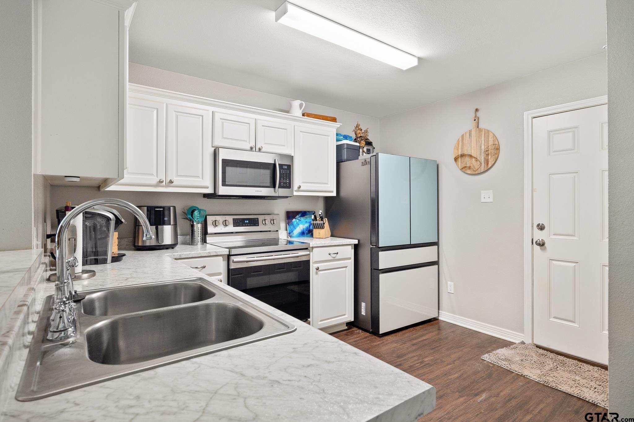 421 Alexander Street Kilgore, TX 75662 - Photo 10 of 24 a kitchen with granite countertop a refrigerator and a sink