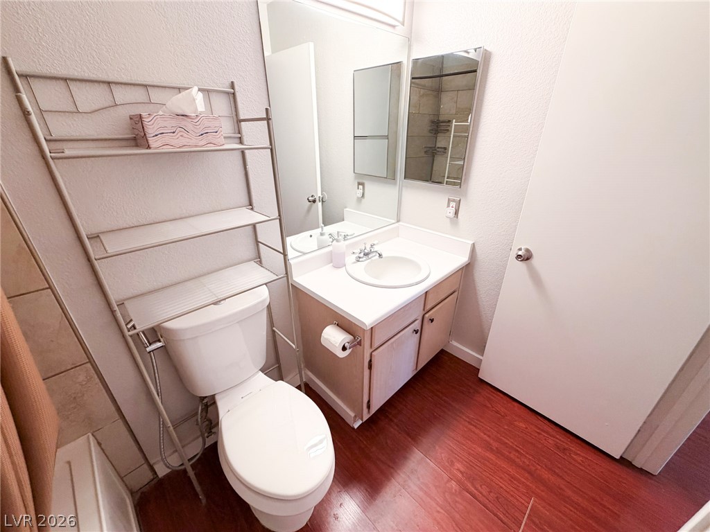 5211 South Lindell Road, Unit 105 Las Vegas, NV 89118 - Photo 14 of 19 Rich wood floors bring warmth to this classic bathroom setup featuring a clean single vanity.