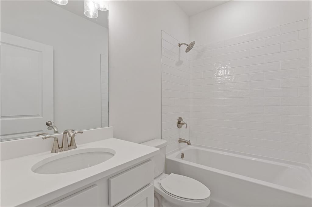 15 Overview Court Hoschton, GA 30548 - Photo 10 of 16 a bathroom with a granite countertop sink toilet and shower