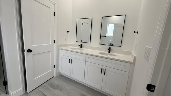 a spacious bathroom with 2 sink toilet and a mirror