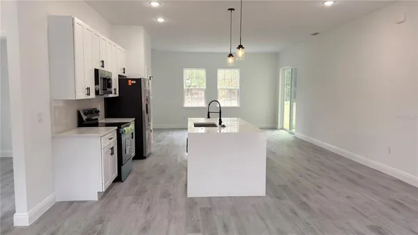 a large kitchen with stainless steel appliances a refrigerator and a sink