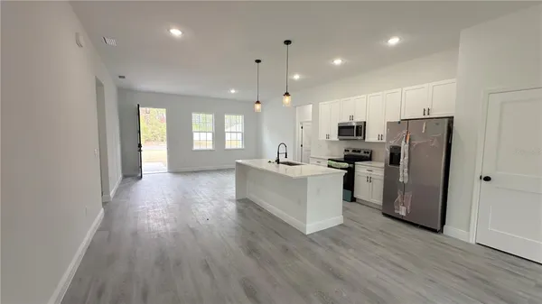 a kitchen with stainless steel appliances a refrigerator sink and microwave