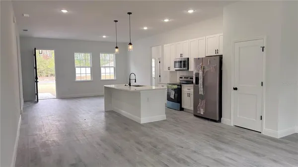 a kitchen with stainless steel appliances a refrigerator sink and microwave