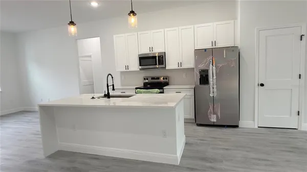 a kitchen with stainless steel appliances granite countertop a sink stove and wooden floor