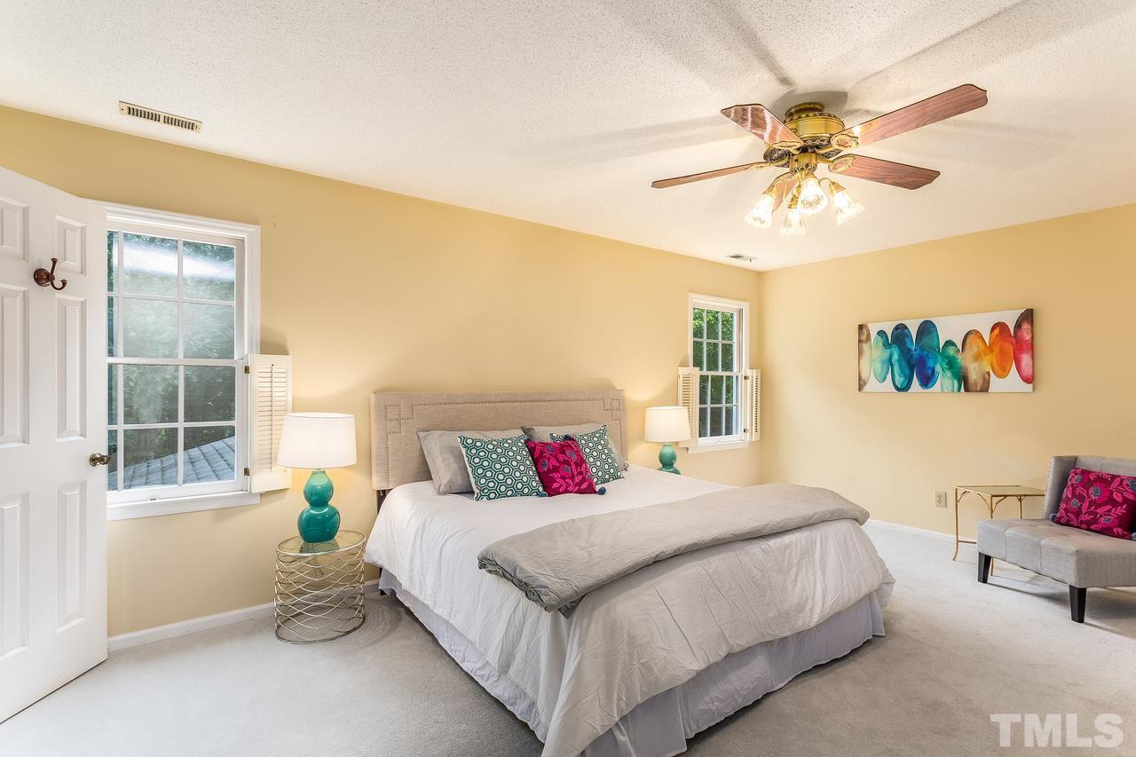 1841 Snow Wind Drive Raleigh, NC 27615 - Photo 14 of 29 a bedroom with a bed and a chandelier