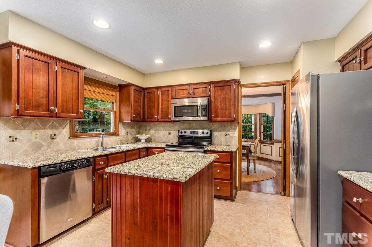 1841 Snow Wind Drive Raleigh, NC 27615 - Photo 8 of 29 a kitchen with a refrigerator a microwave a sink and chairs