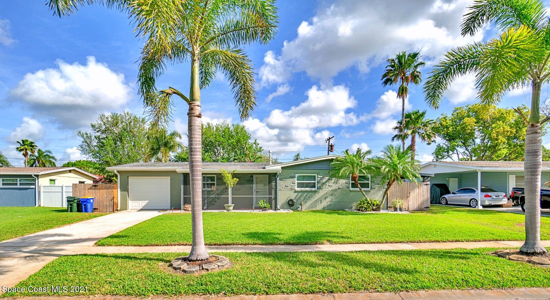 1096 Madrid Road Rockledge, FL 32955 - Photo 3 of 41 a front view of a house with a garden and trees