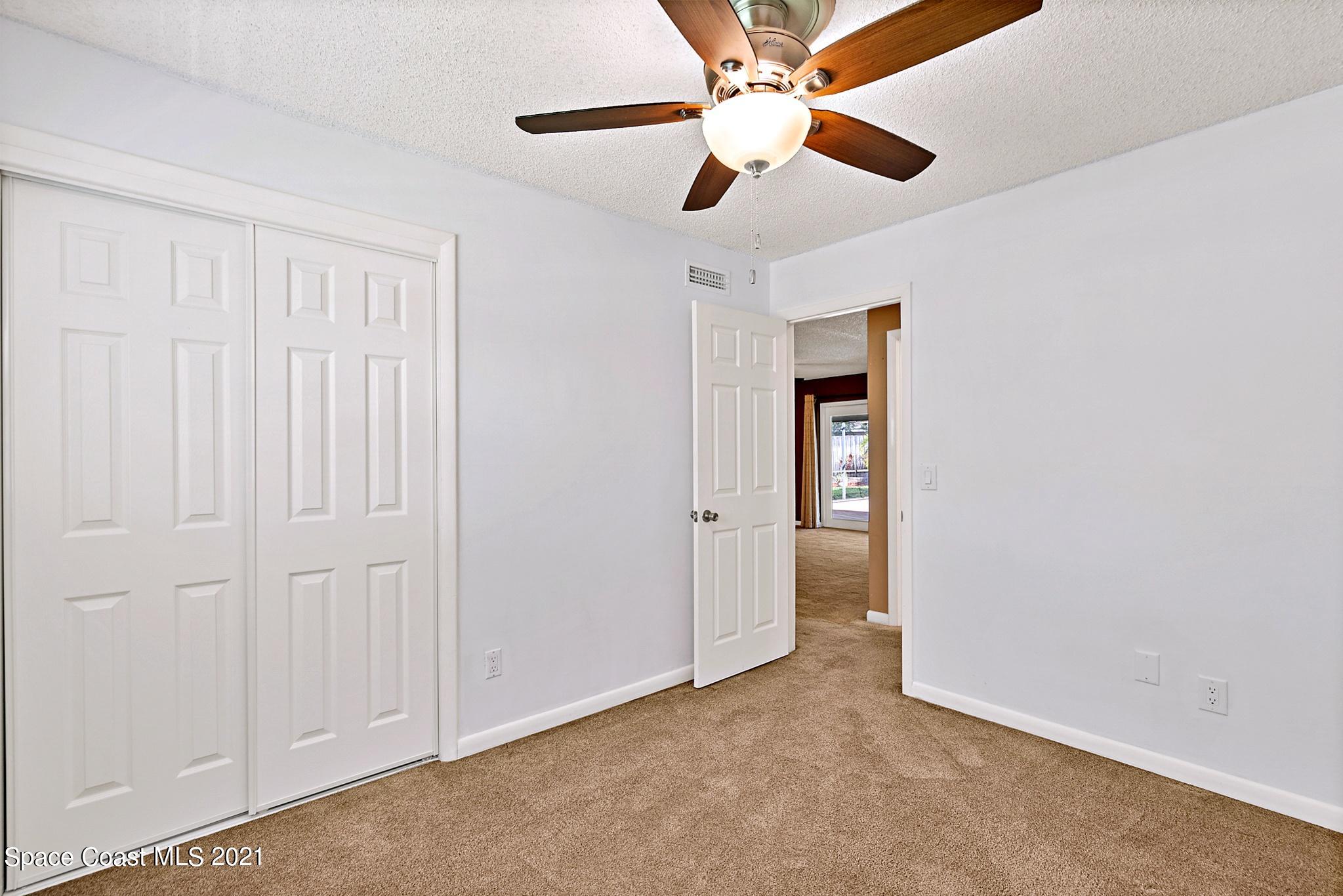1096 Madrid Road Rockledge, FL 32955 - Photo 22 of 41 an empty room with ceiling fan and window