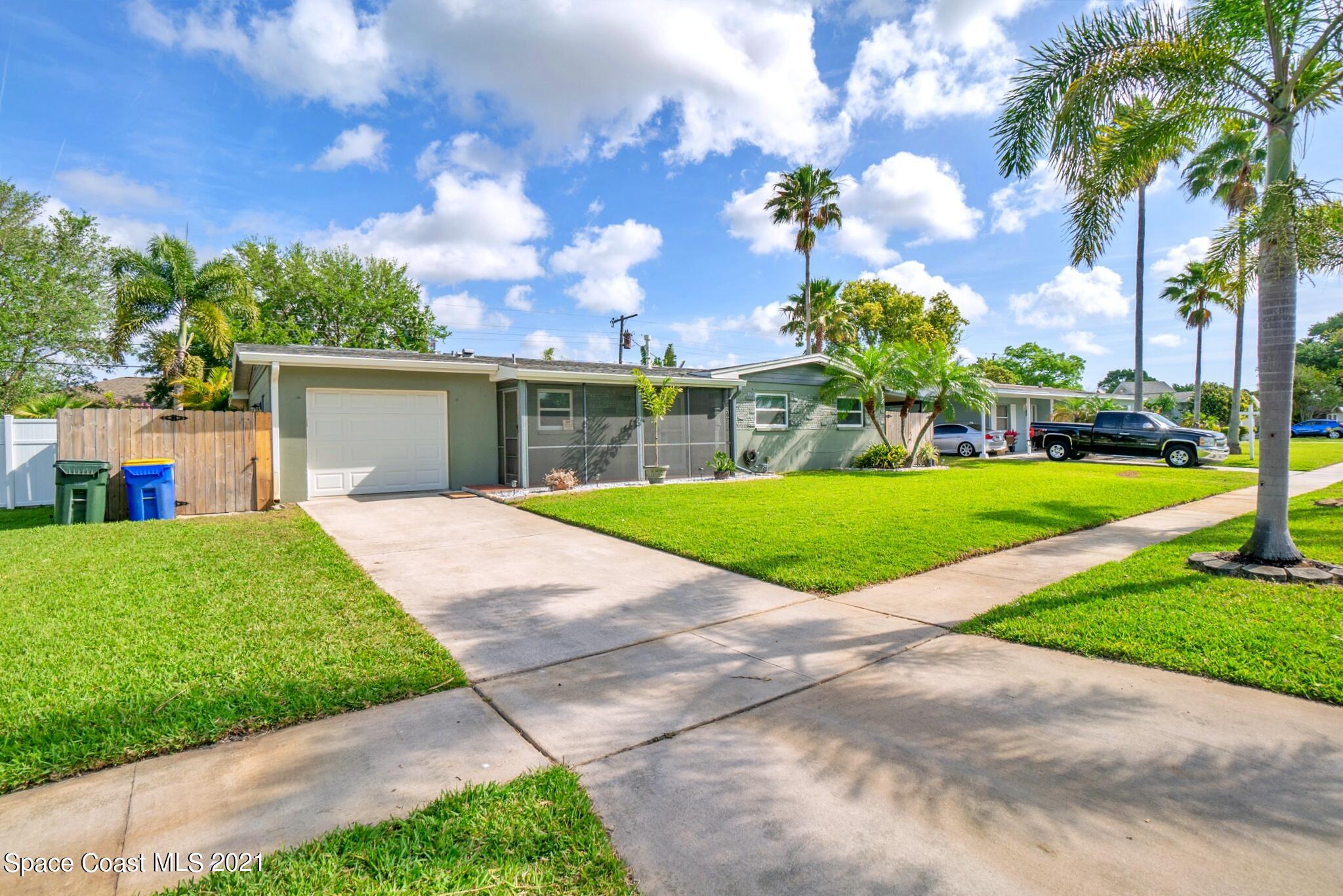 1096 Madrid Road Rockledge, FL 32955 - Photo 4 of 41 a view of a house with a big yard plants and palm trees