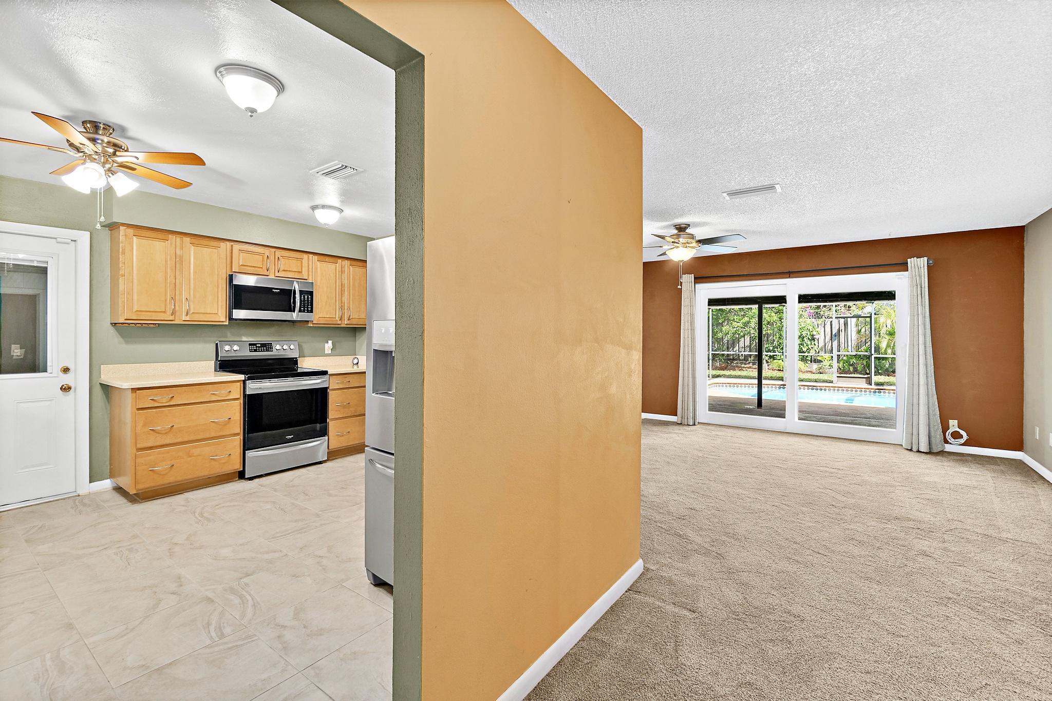 1096 Madrid Road Rockledge, FL 32955 - Photo 8 of 41 a kitchen with granite countertop a stove top oven and refrigerator