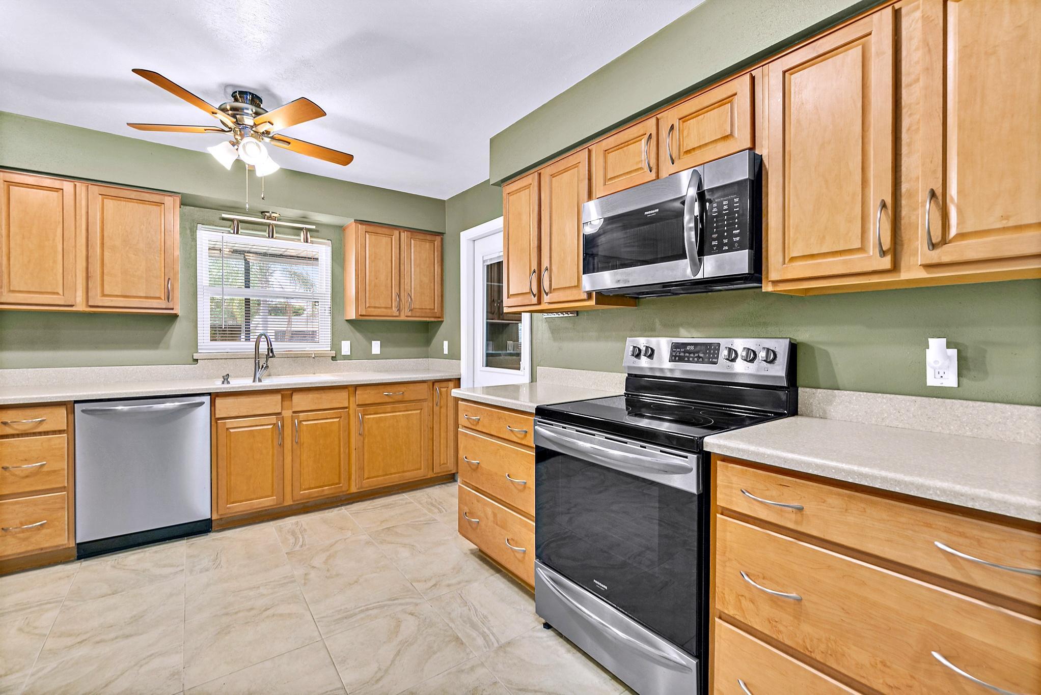 1096 Madrid Road Rockledge, FL 32955 - Photo 9 of 41 a kitchen with stainless steel appliances granite countertop a stove cabinets and a sink
