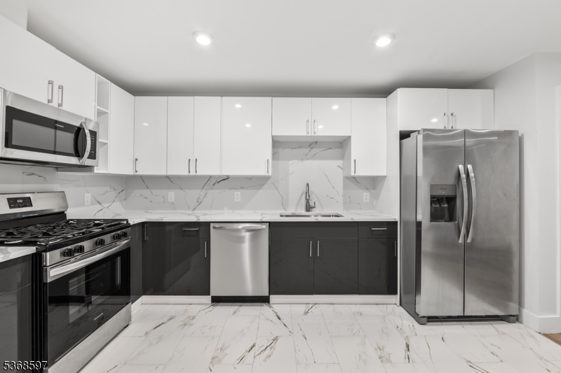 180 Carroll Street Paterson, NJ 07501 - Photo 12 of 31 a kitchen with granite countertop a refrigerator and a stove top oven