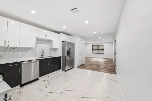 a large kitchen with kitchen island a sink stainless steel appliances and cabinets