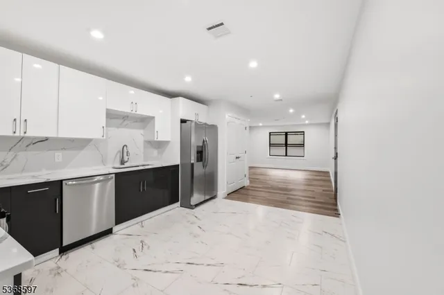 a large kitchen with kitchen island a sink stainless steel appliances and cabinets