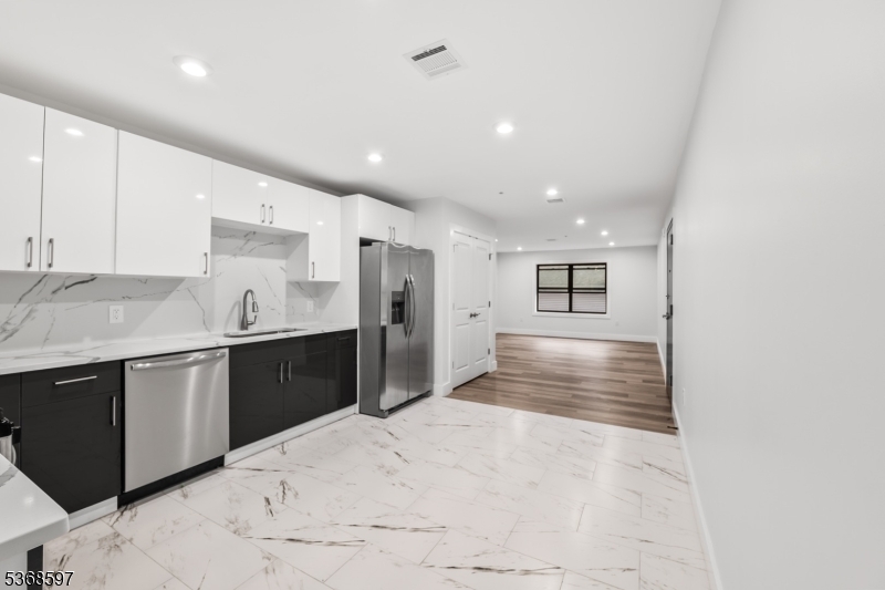 180 Carroll Street Paterson, NJ 07501 - Photo 13 of 31 a large kitchen with kitchen island a sink stainless steel appliances and cabinets