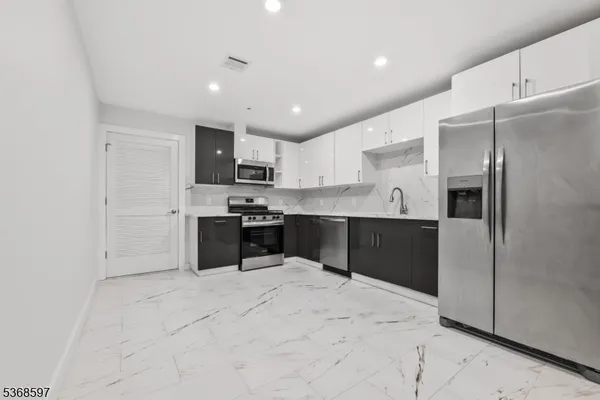 a kitchen with stainless steel appliances kitchen island granite countertop a refrigerator sink and cabinets