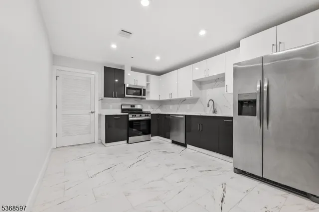 a kitchen with stainless steel appliances kitchen island granite countertop a refrigerator sink and cabinets