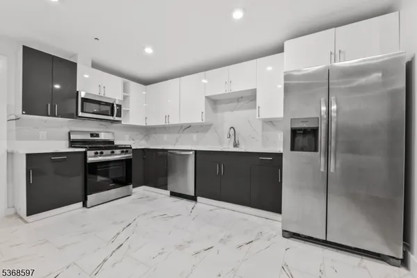 a kitchen with granite countertop a refrigerator and a stove top oven