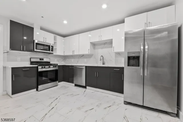 a kitchen with granite countertop a refrigerator and a stove top oven