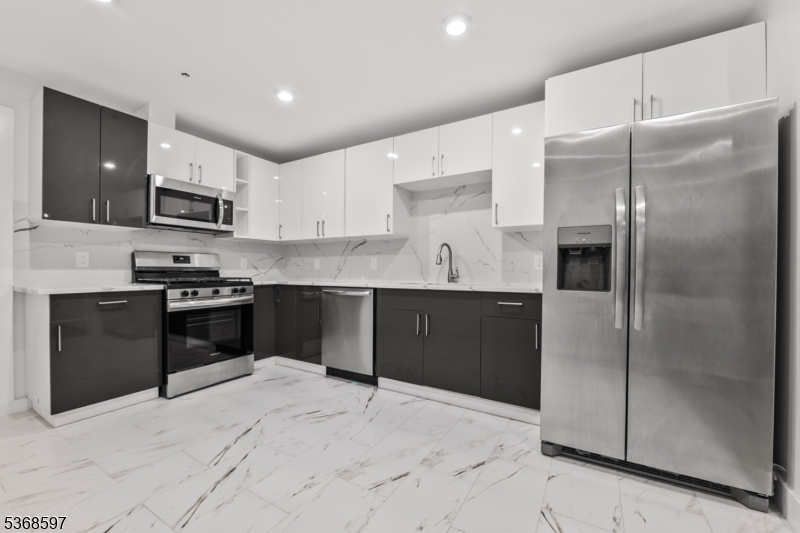 180 Carroll Street Paterson, NJ 07501 - Photo 15 of 31 a kitchen with granite countertop a refrigerator and a stove top oven