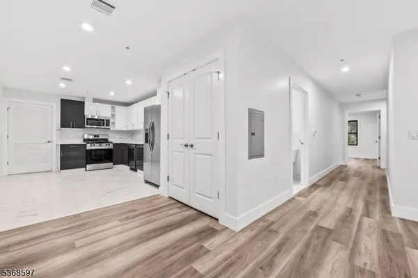 a view of a kitchen with a refrigerator wooden floor and a sink
