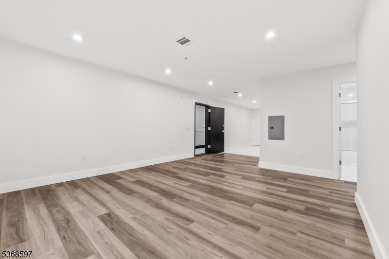 180 Carroll Street Paterson, NJ 07501 - Photo 17 of 31 a view of an empty room with wooden floor and a window