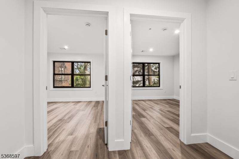 180 Carroll Street Paterson, NJ 07501 - Photo 19 of 31 an empty room with wooden floor and windows