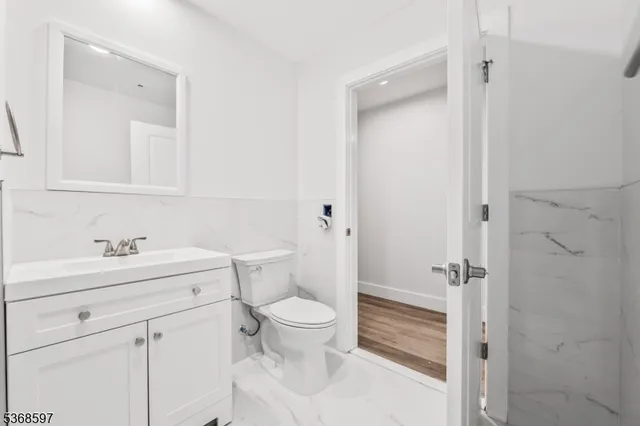 a bathroom with a sink a toilet a vanity and mirror