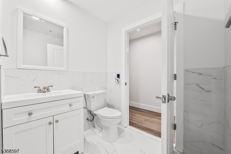180 Carroll Street Paterson, NJ 07501 - Photo 22 of 31 a bathroom with a sink a toilet a vanity and mirror