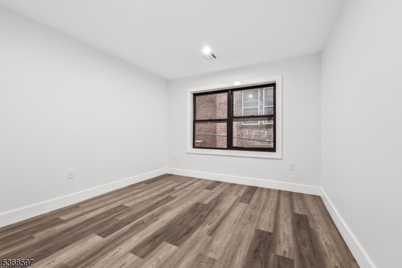 180 Carroll Street Paterson, NJ 07501 - Photo 27 of 31 wooden floor in an empty room with a window