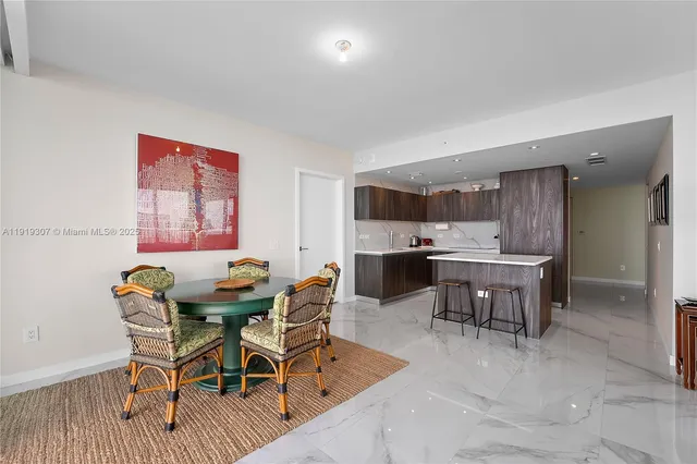 a kitchen with a table chairs refrigerator and cabinets