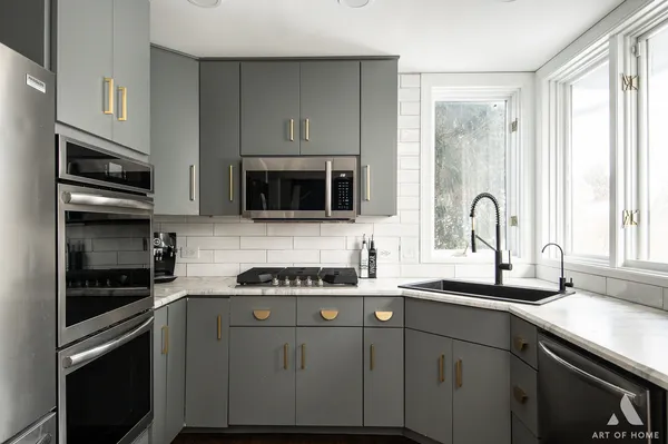 a kitchen with stainless steel appliances a sink stove and microwave