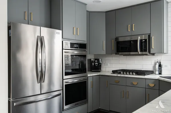 a kitchen with refrigerator a microwave a sink and cabinets