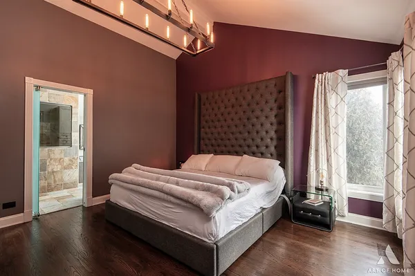 a bed sitting in a bedroom next to a window