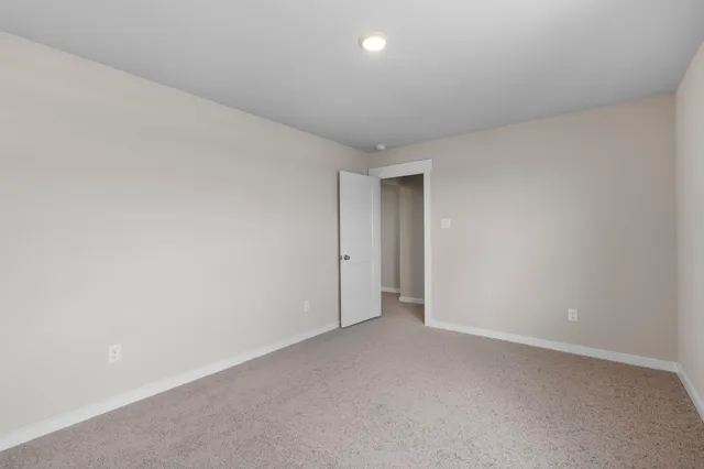 an empty room with a window and a bathroom