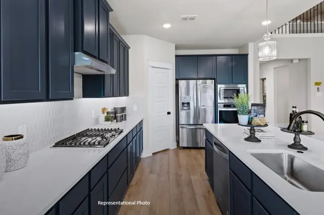 a kitchen with stainless steel appliances a sink and a refrigerator