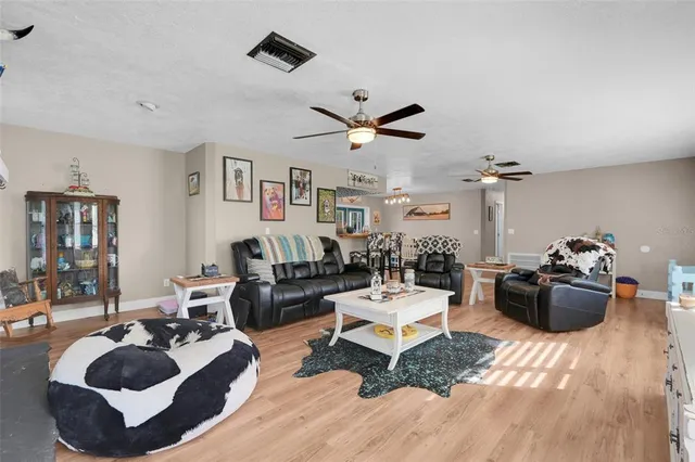 a living room with furniture and view of kitchen