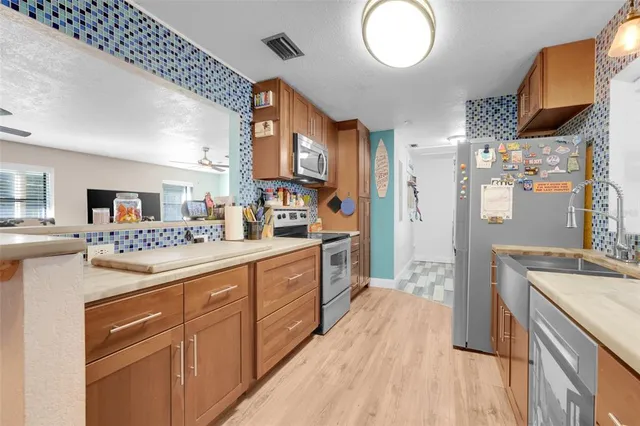 a large kitchen with a lot of counter space and wooden floor