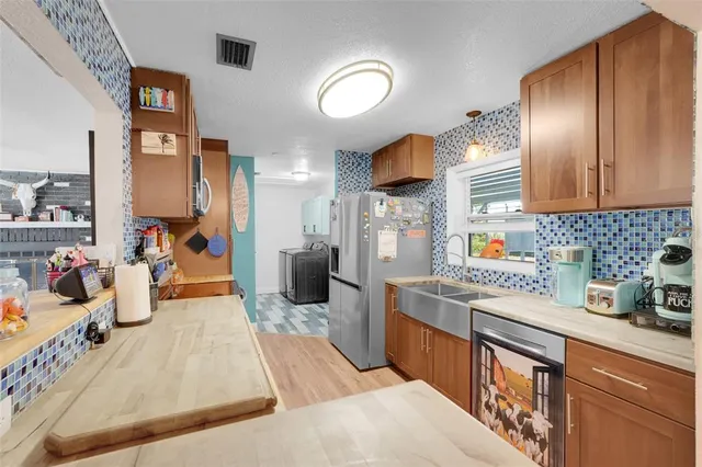 a kitchen with stainless steel appliances granite countertop a sink dishwasher stove and refrigerator